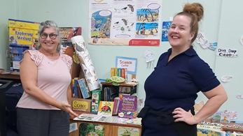 Country Director Kim and PCV pose in front of a School Library in the Eastern Caribbean