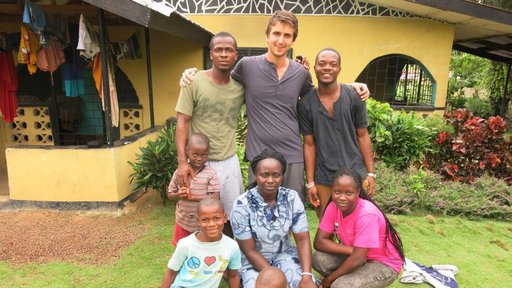 Joe stands with his Liberian family