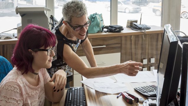 Lisa Gill works with a student at a career program in her community.
