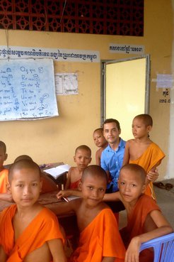 Latinx Volunteer teaches young Cambodian monks in his community.