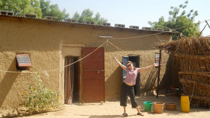 Lisa stands in front of her house in Niger.