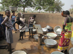 Togolese community members using a water pump in their village.