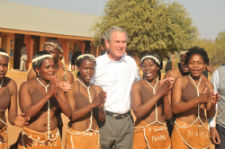President Bush is greeted by traditional dancers at the Gabane Community Home-Based Care Center.