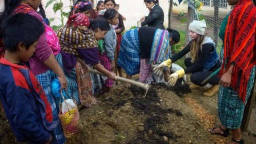Peace Corps Volunteer Nicole Mortenson plants a demonstrative garden with mothers.