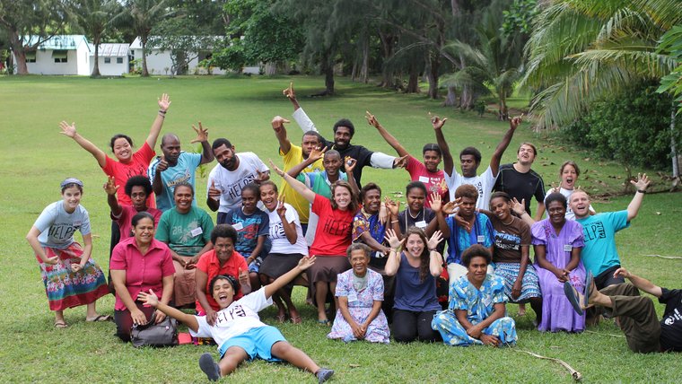 A group of volunteers and local residents smile