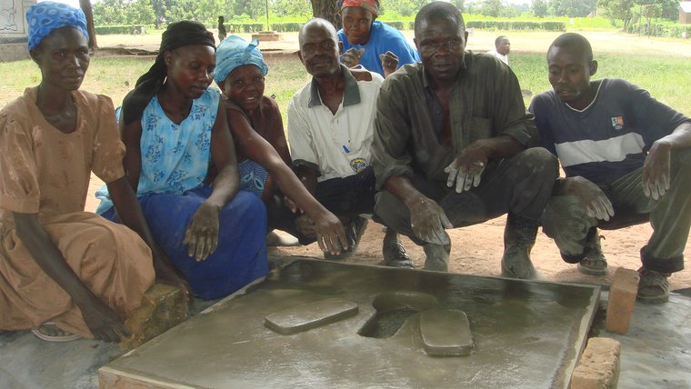 Uganda: Volunteer health team with the completed cement pit latrine.