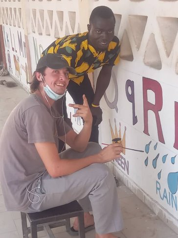 Haldan and Yaya, his school counterpart, work on educational murals at the school.