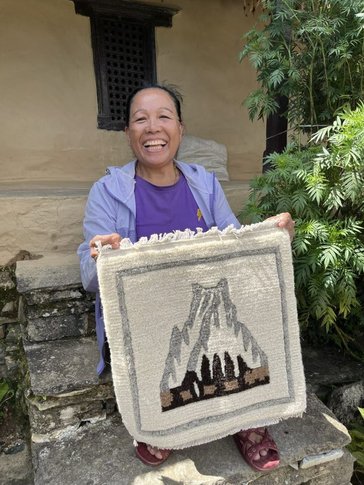 purnima shows a carpet she wove in Nepal