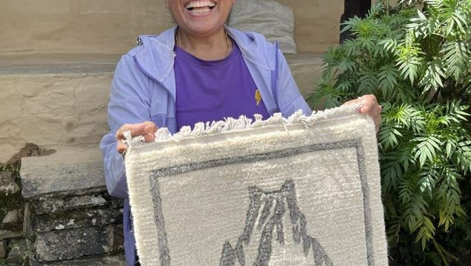 purnima shows a carpet she wove in Nepal