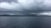 Storm clouds accumulate over a grey Lake Malawi