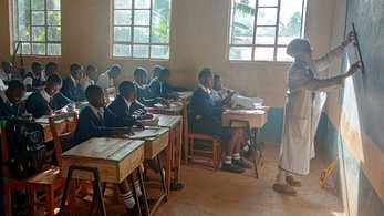 Peace Corps Kenya Volunteer Marie Writing on the Board as her Students Watch