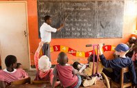 A teacher in Malawi teaches young children in a small classroom
