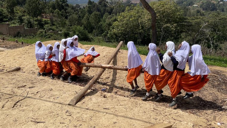 Students improvise a seesaw in Tanzania.