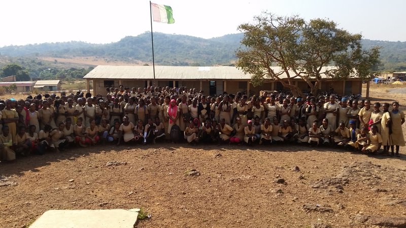 Students posing in front of school