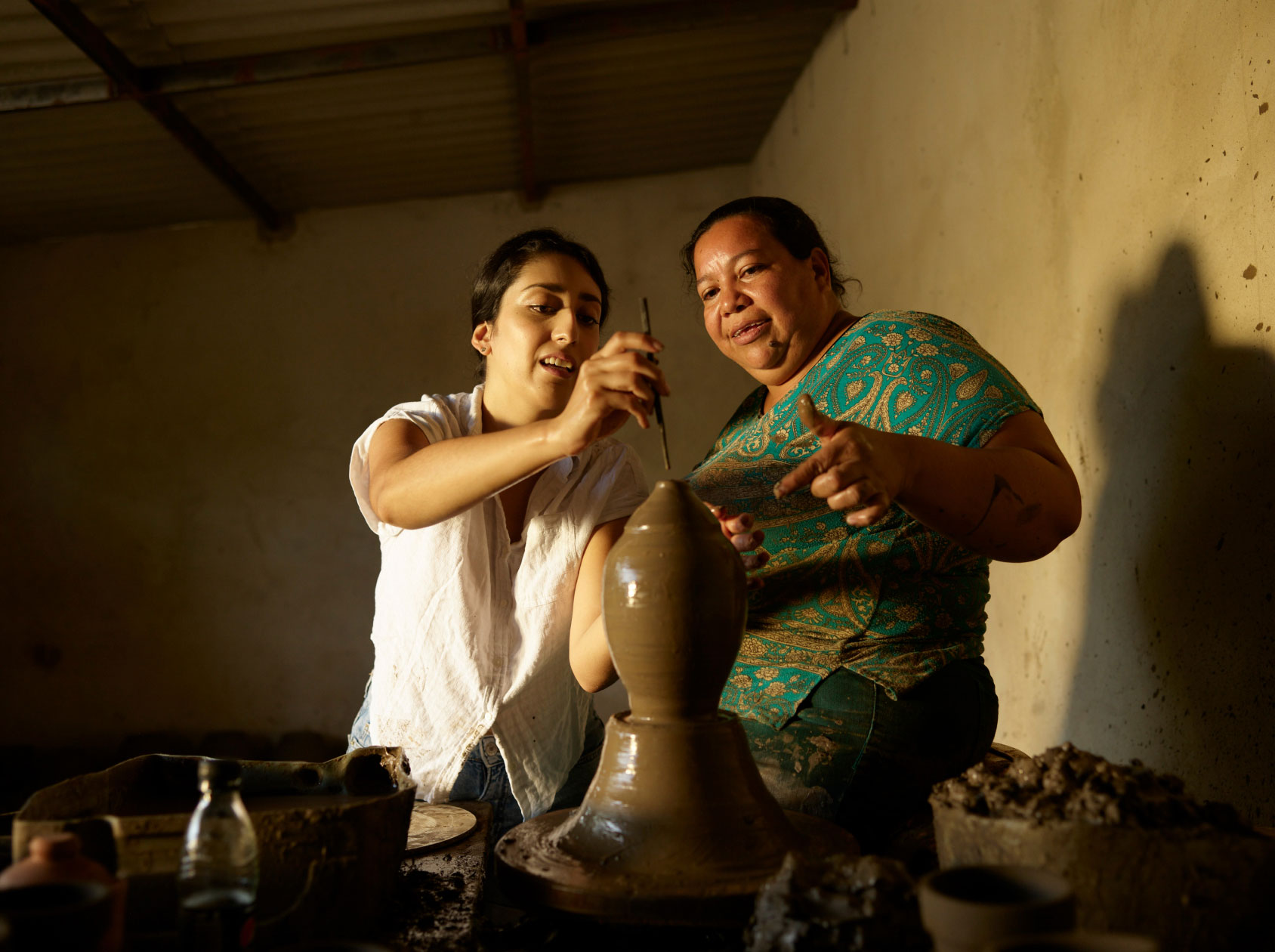 Two people spinning clay