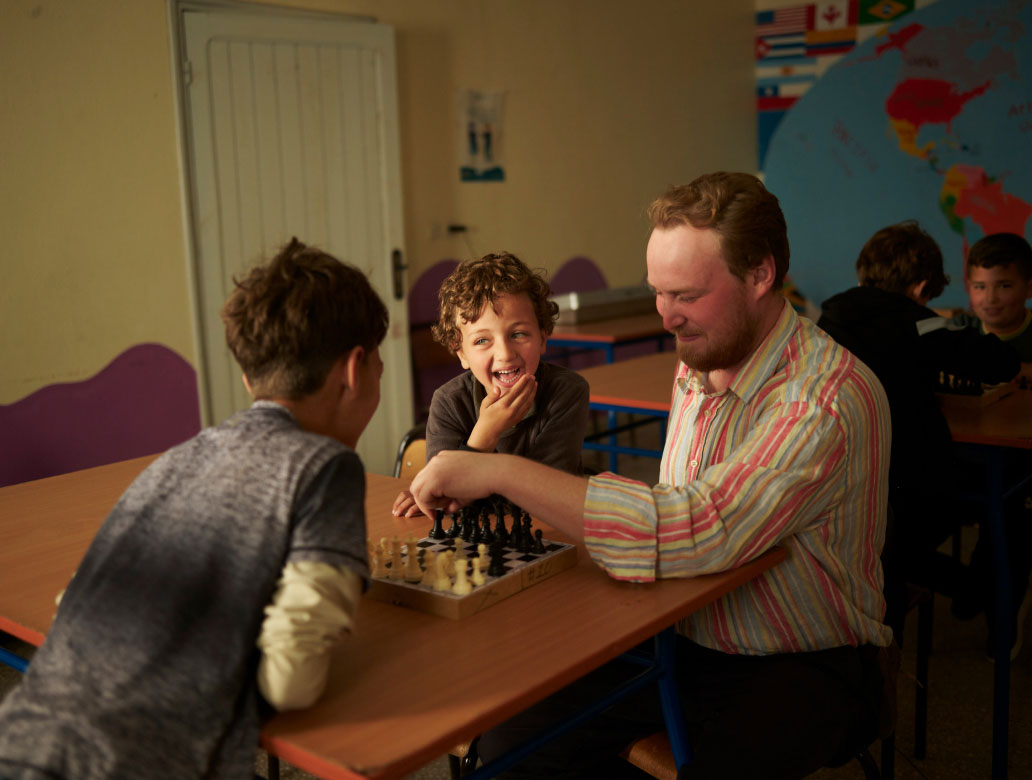 Person playing chess with two children